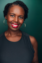 A professional photo of Kayla Leacock. She's wearing a black tanktop and has on bright red lipstick.