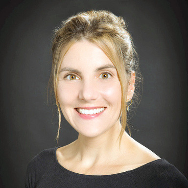 A professional headshot of Kirsten Kumpf Baele on a dark background.